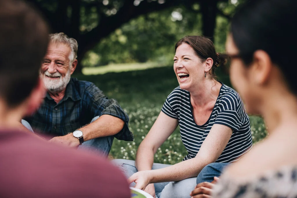 Adults laughing together in an outdoor small group