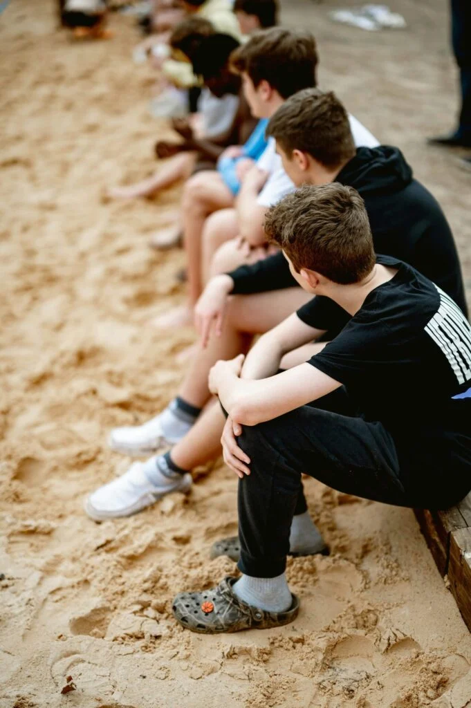 Teens sitting together on a sandy beach
