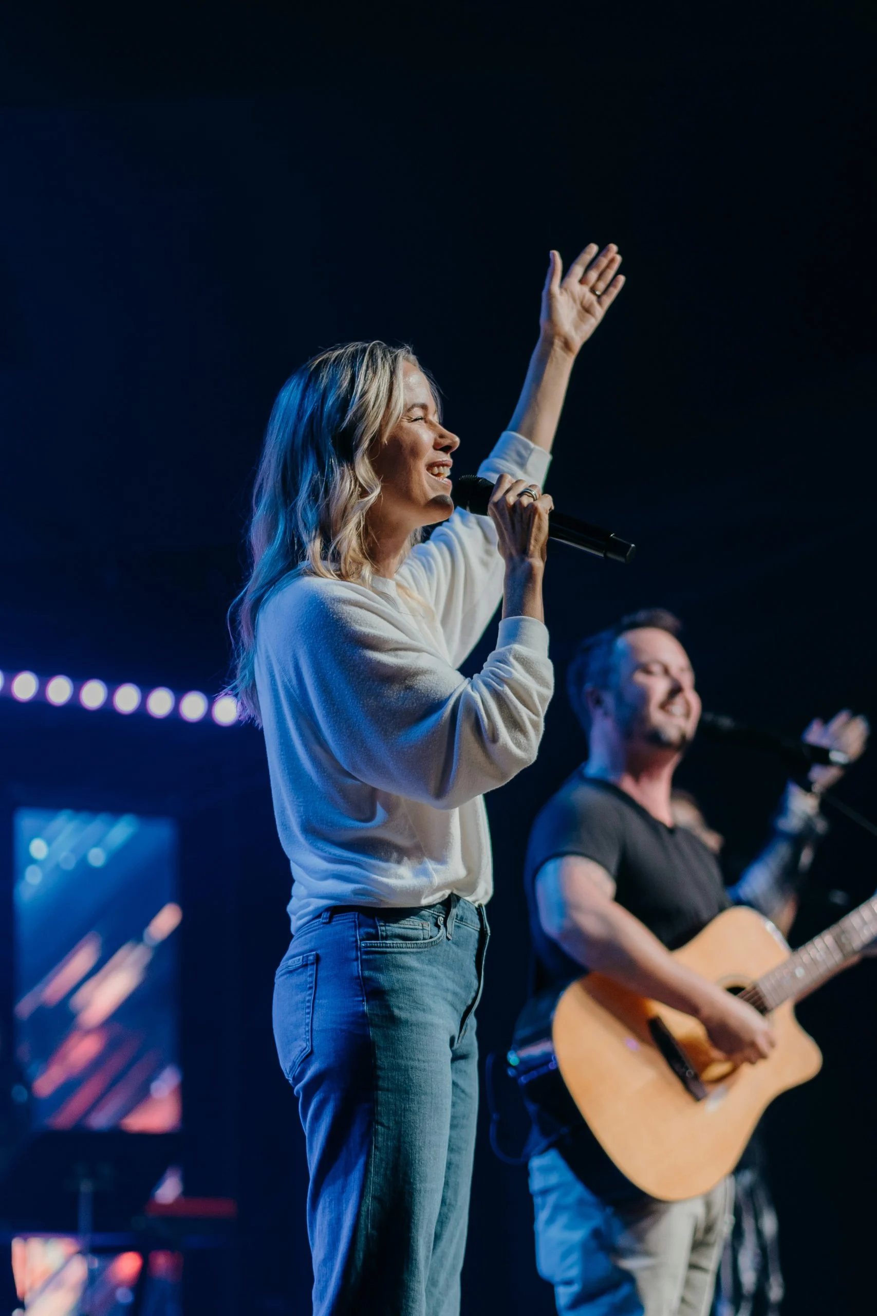 A worship band on a stage washed in blue light